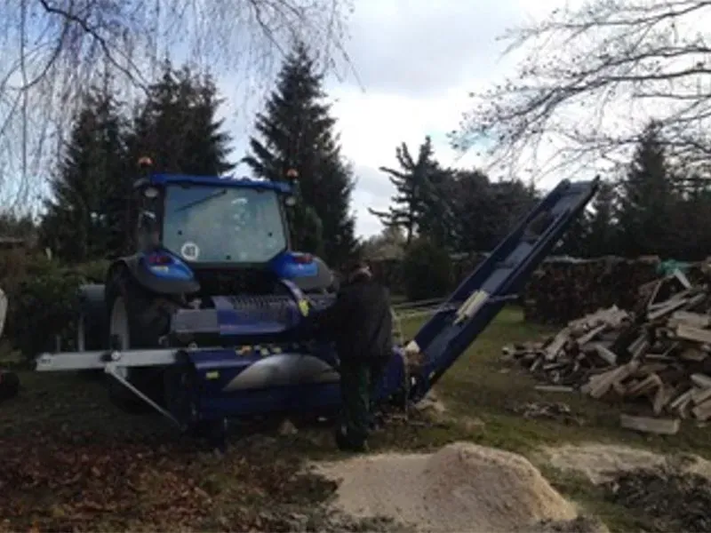 Ein blauer Traktor mit einem daran befestigten Förderband, Gala Bau & Service GbR