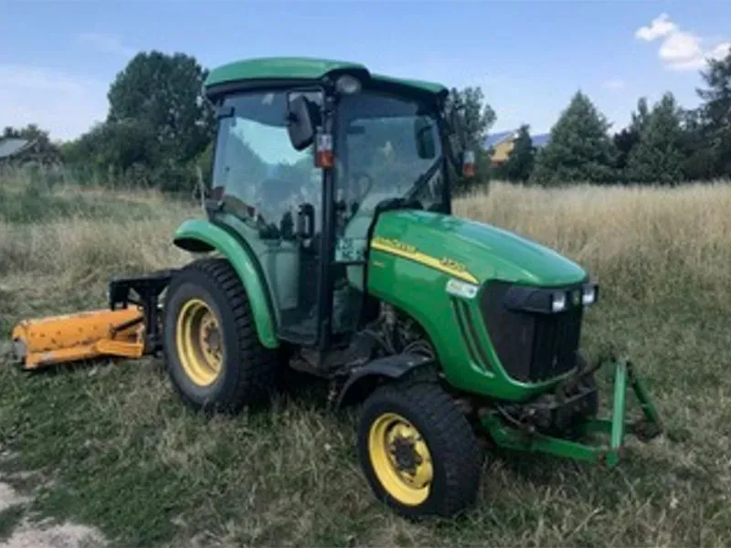 Ein grüner John Deere-Traktor ist auf einer Wiese geparkt. Gala Bau & Service GbR