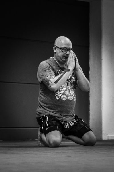 kniender Mann beim Kampfsport