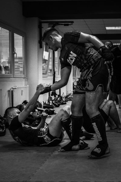 Mann hilft anderem, am Boden liegenden Mann auf