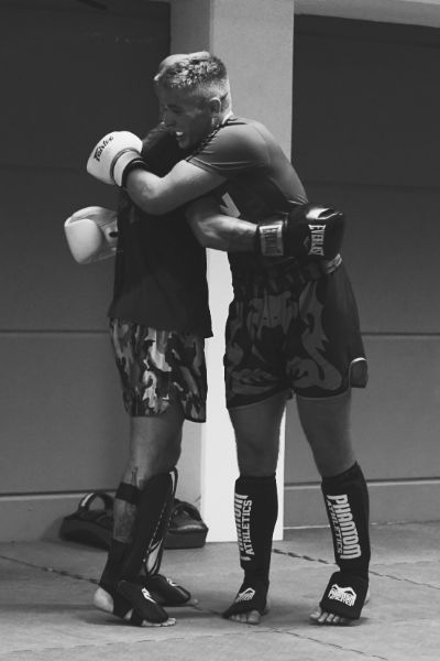 zwei Männer mit Boxhandschuhen umarmen sich
