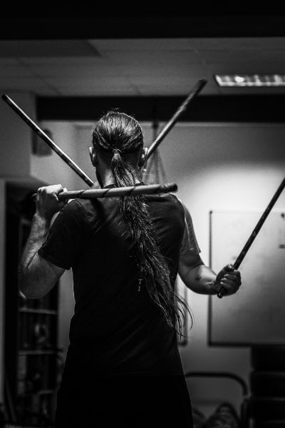 Mann kämpft mit Kali-Stöcken