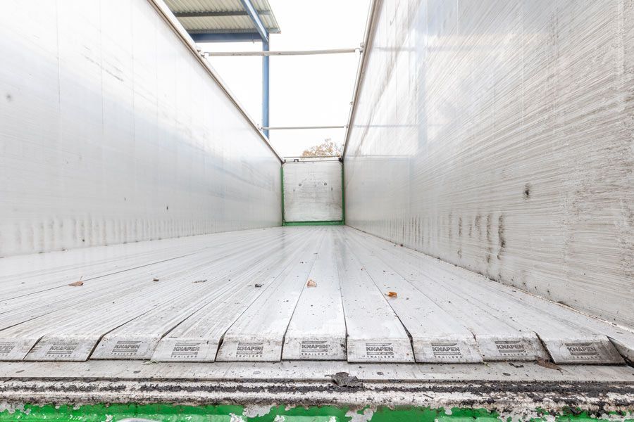 Das Innere eines leeren Anhängers mit einem grünen Streifen an der Seite.