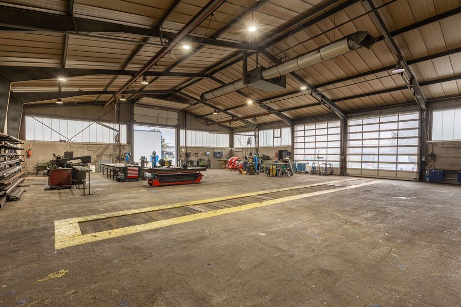 Eine große leere Lagerhalle mit vielen Maschinen darin.