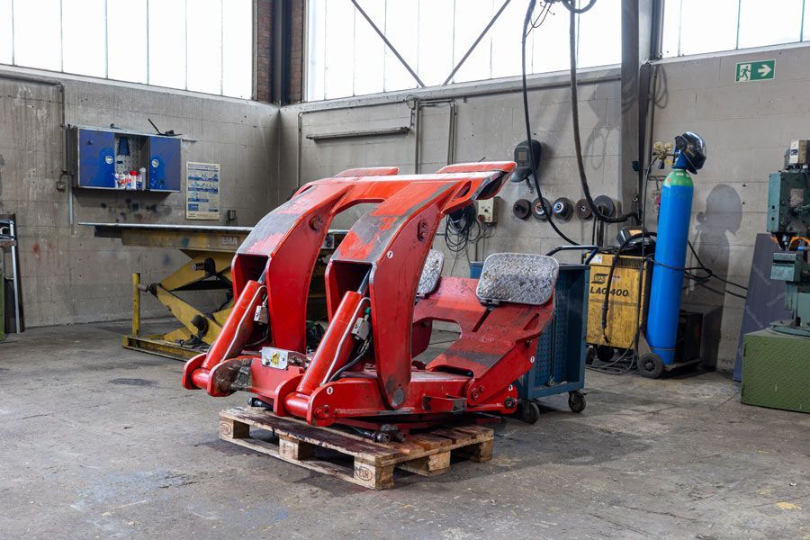Eine rote Maschine steht auf einer Palette in einer Garage.