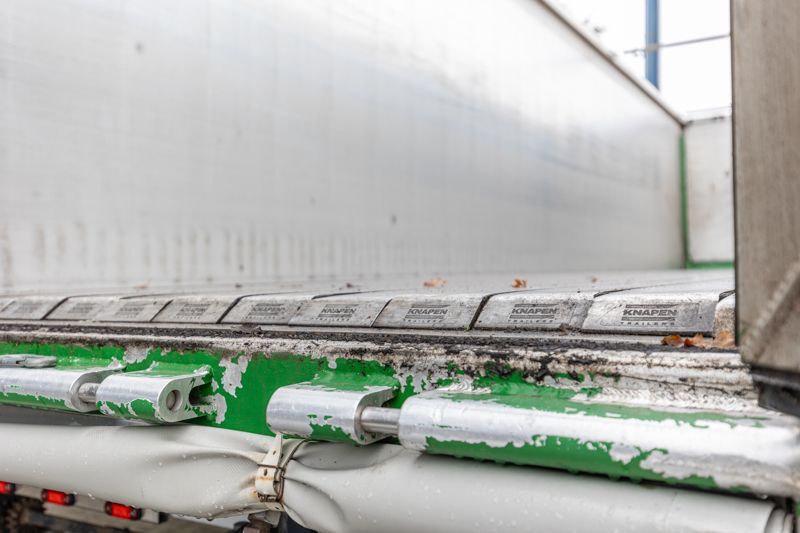 Eine Nahaufnahme der Rückseite eines Sattelschleppers mit einem Grüngürtel.