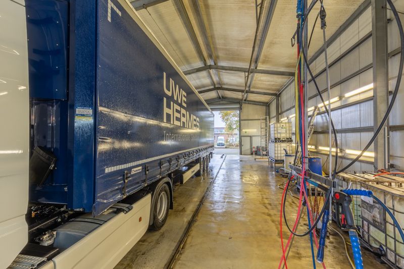 Ein blau-weißer Sattelschlepper steht in einer Garage.