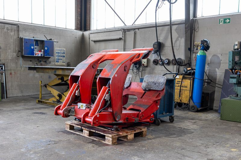 Eine rote Maschine steht auf einer Palette in einer Garage.