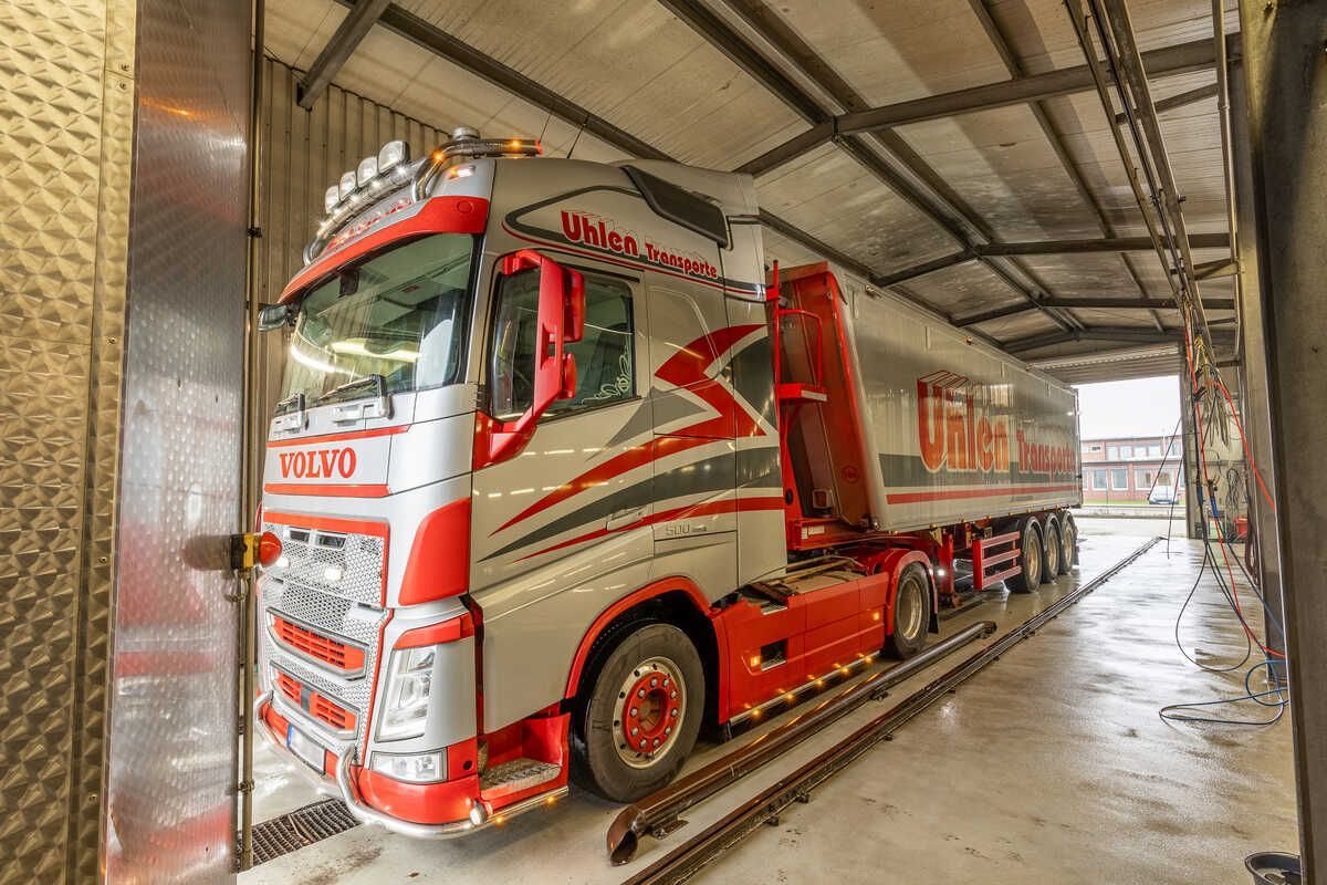 Ein rot-weißer Lastwagen steht in einer Garage.
