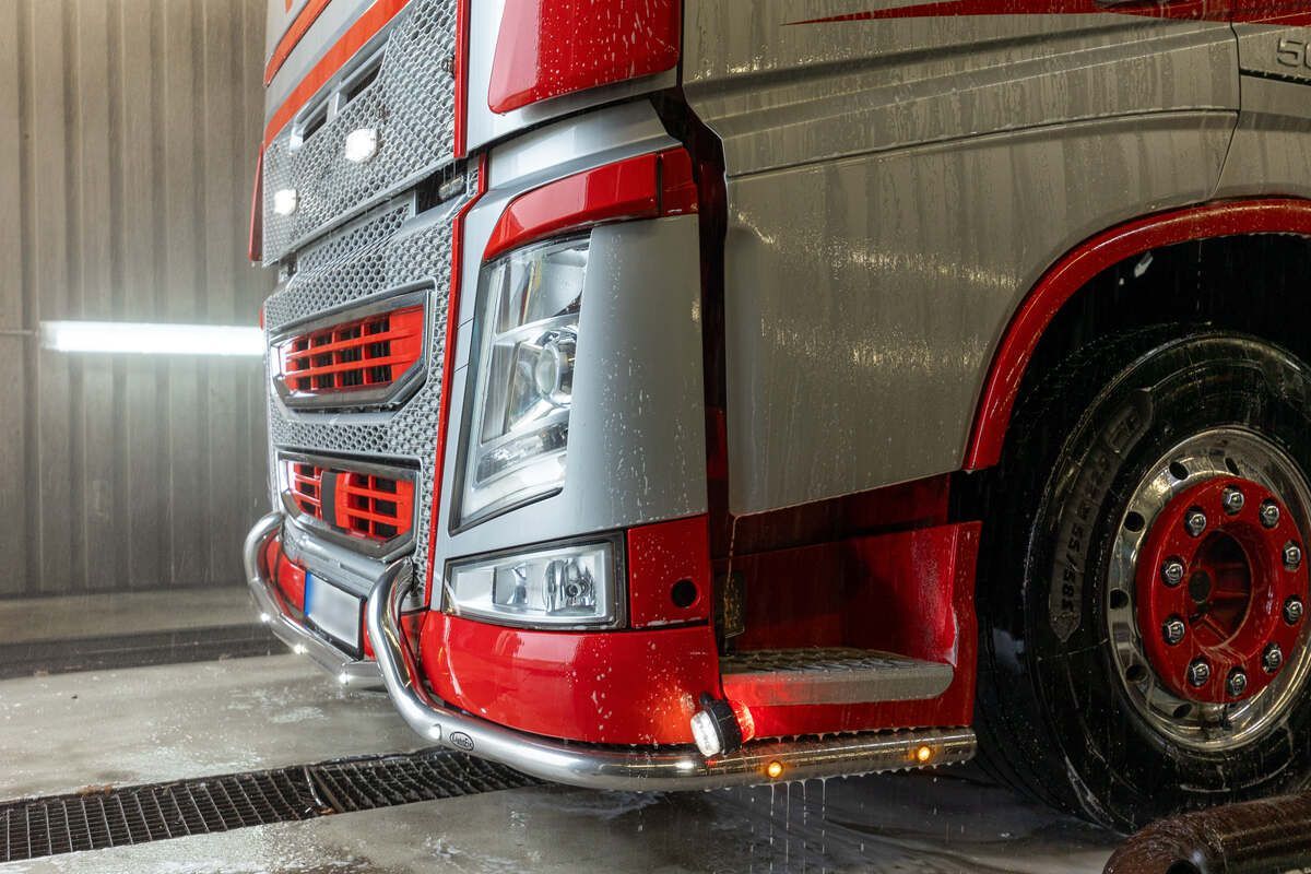 Ein rot-silberner Sattelschlepper steht in einer Garage.