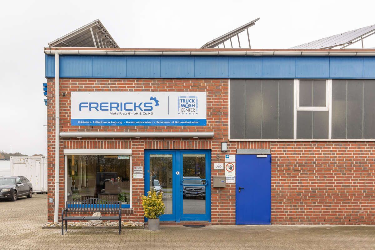 Ein Backsteingebäude mit einer blauen Tür und einem Schild mit der Aufschrift „Frericks“ darauf.