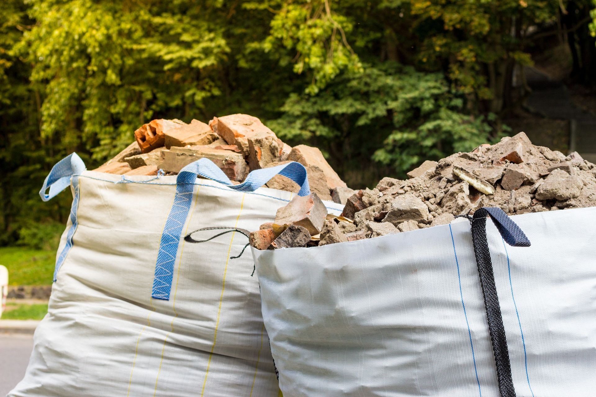 De grands sacs blancs de chantier remplis de gravats.