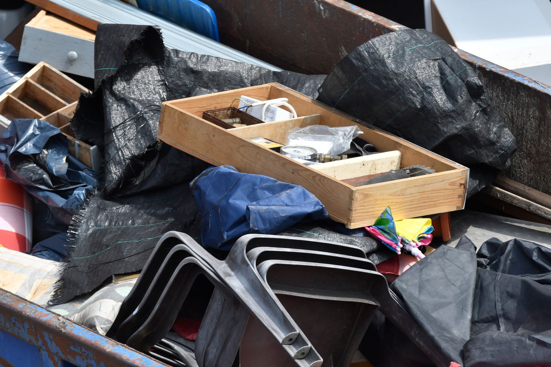 Un tas de sacs-poubelle mélangés, de cartons et de conteneurs en plastique dans une benne.