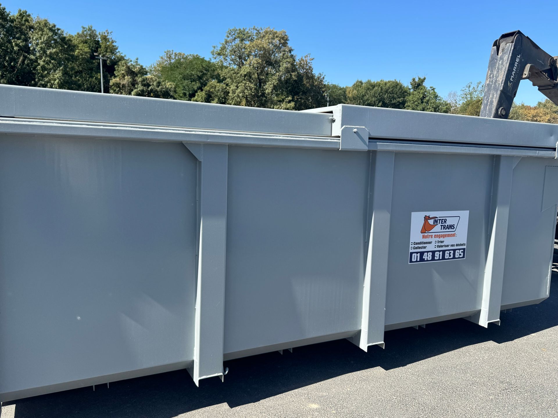 Un grand conteneur à déchets de chantier gris.