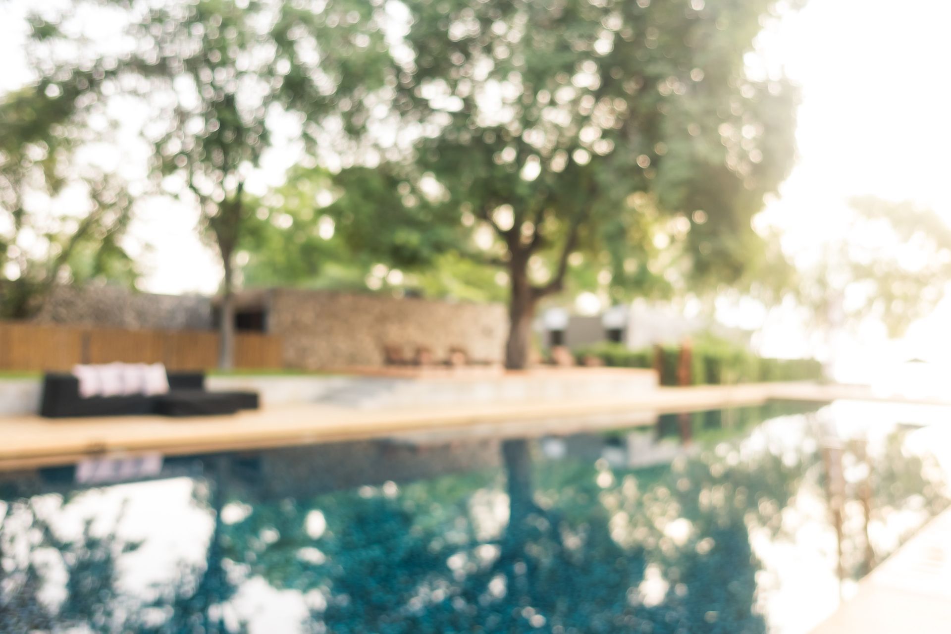 Una imagen borrosa de una piscina con árboles al fondo.