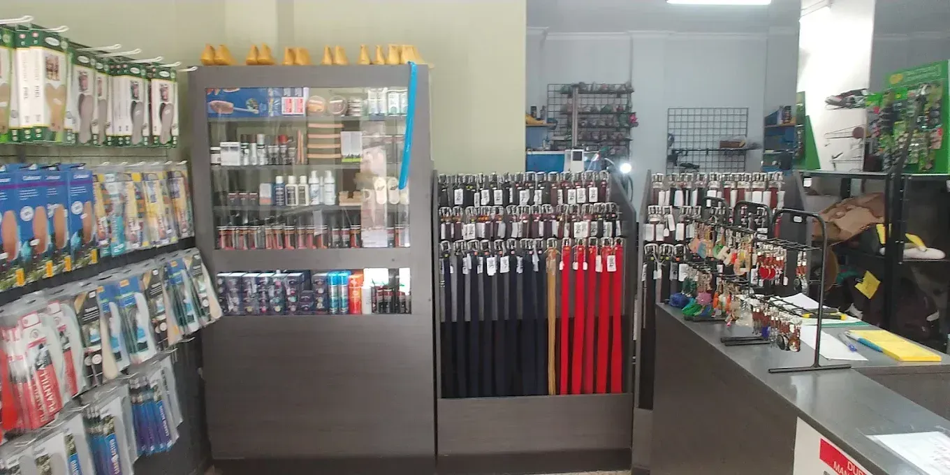 Pasillo de la tienda con productos de aseo, paraguas y estantes con artículos y golosinas para mascotas.