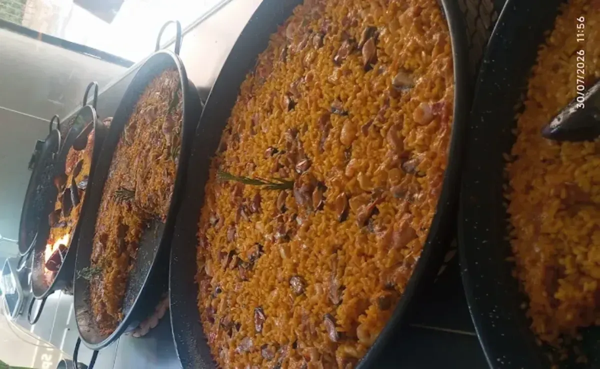 Grandes sartenes de guiso o paella horneadas en el horno, cubiertas con una costra dorada y burbujeante.