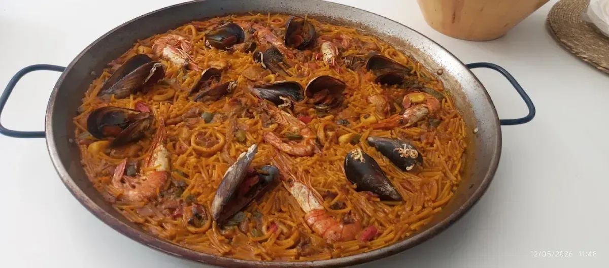 Gran paella de mariscos con mejillones y arroz con azafrán en una estufa.