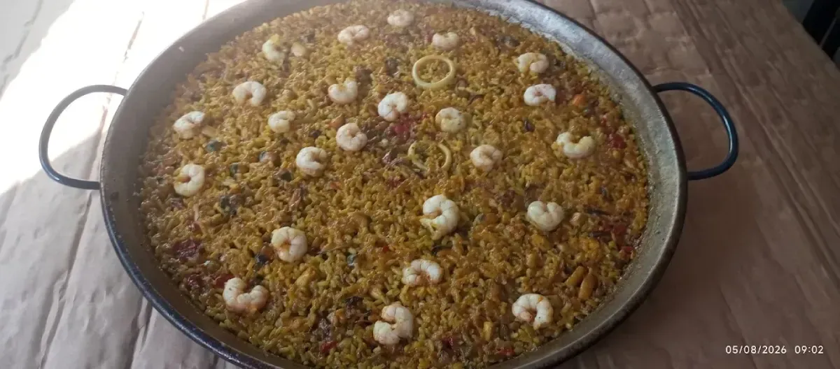 Gran fuente de arroz cubierta con huevos cocidos en rodajas sobre una superficie de madera.
