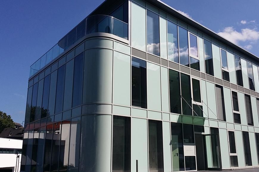 Ein großes Gebäude mit vielen Fenstern und einem Balkon.