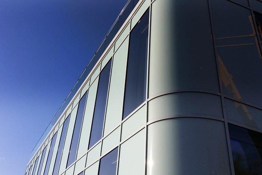 Ein Gebäude mit vielen Fenstern und einem blauen Himmel im Hintergrund