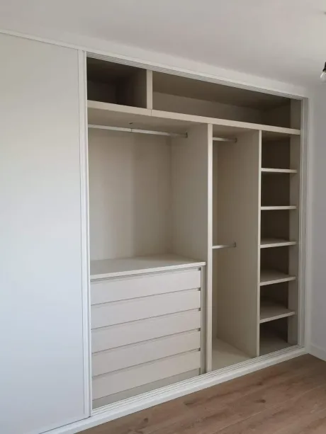 Cocina moderna minimalista con gabinetes de madera, isla con asientos y lámparas colgantes.