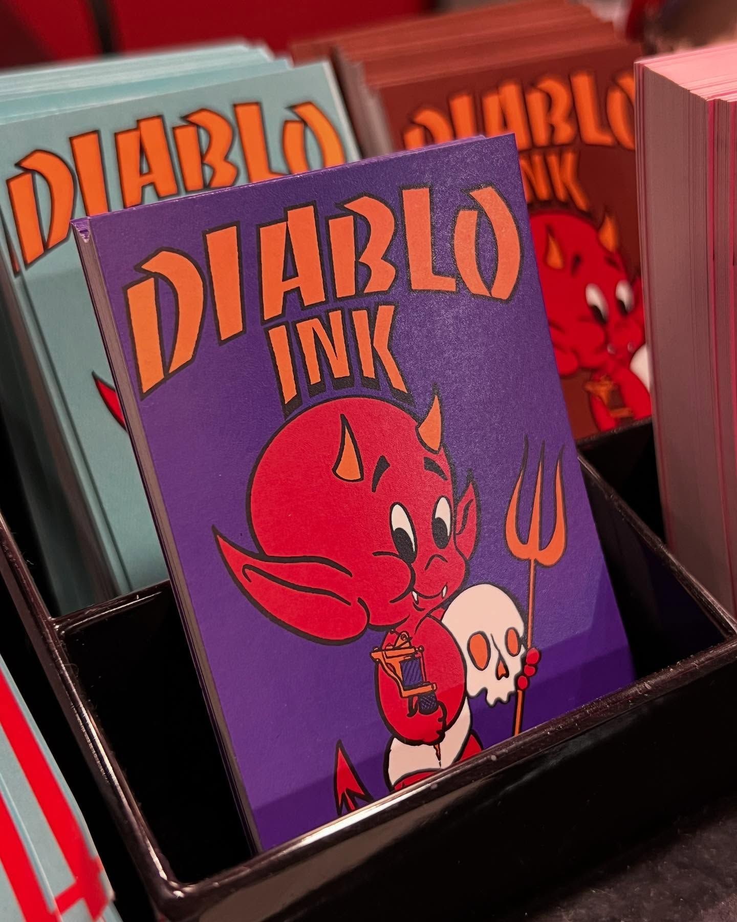Pila de cuadernos de Diablo Ink que presentan un diablo de dibujos animados con una horca y una calavera.