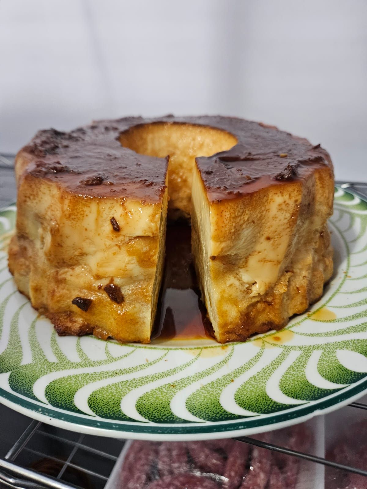 Pierna de cordero con patatas y romero en plato decorativo.