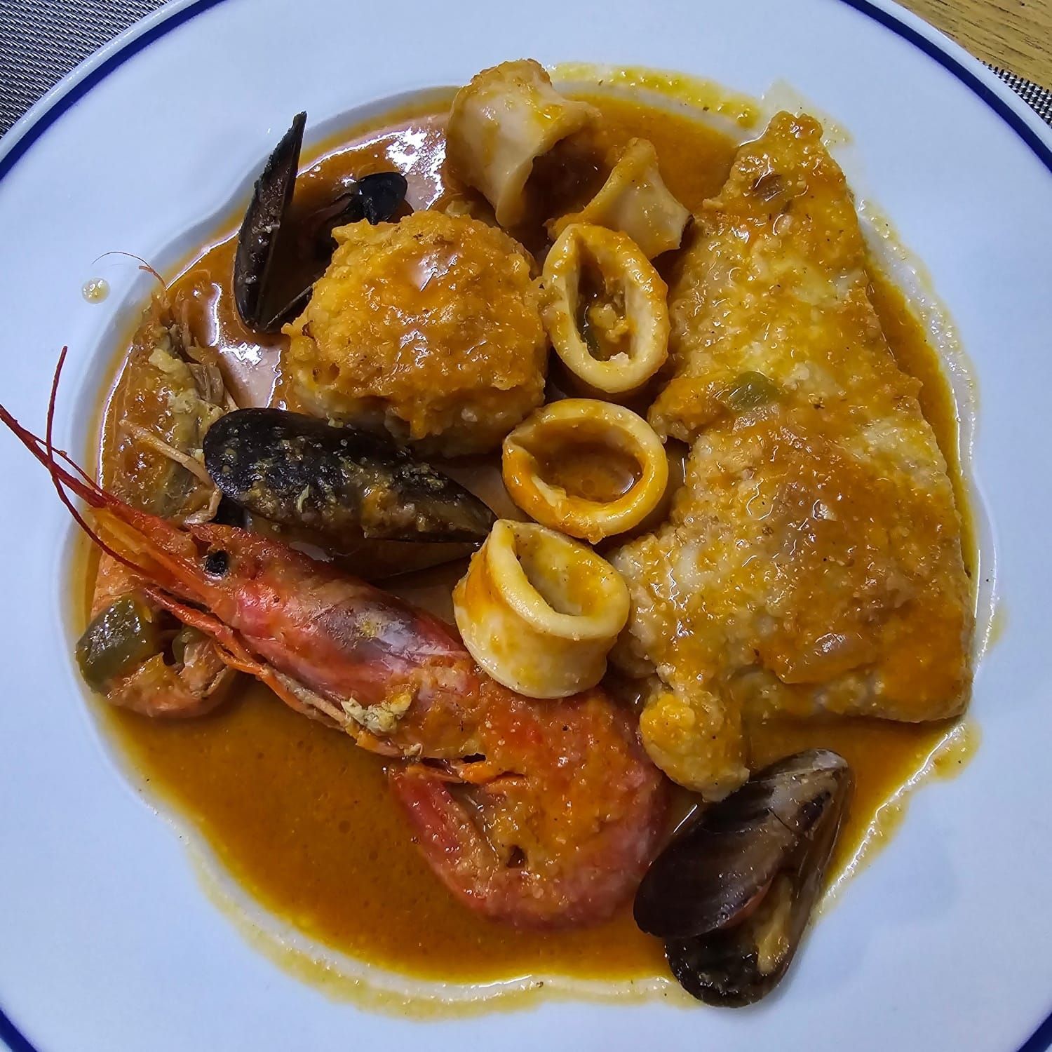 Pierna de cordero con patatas y romero en plato decorativo.