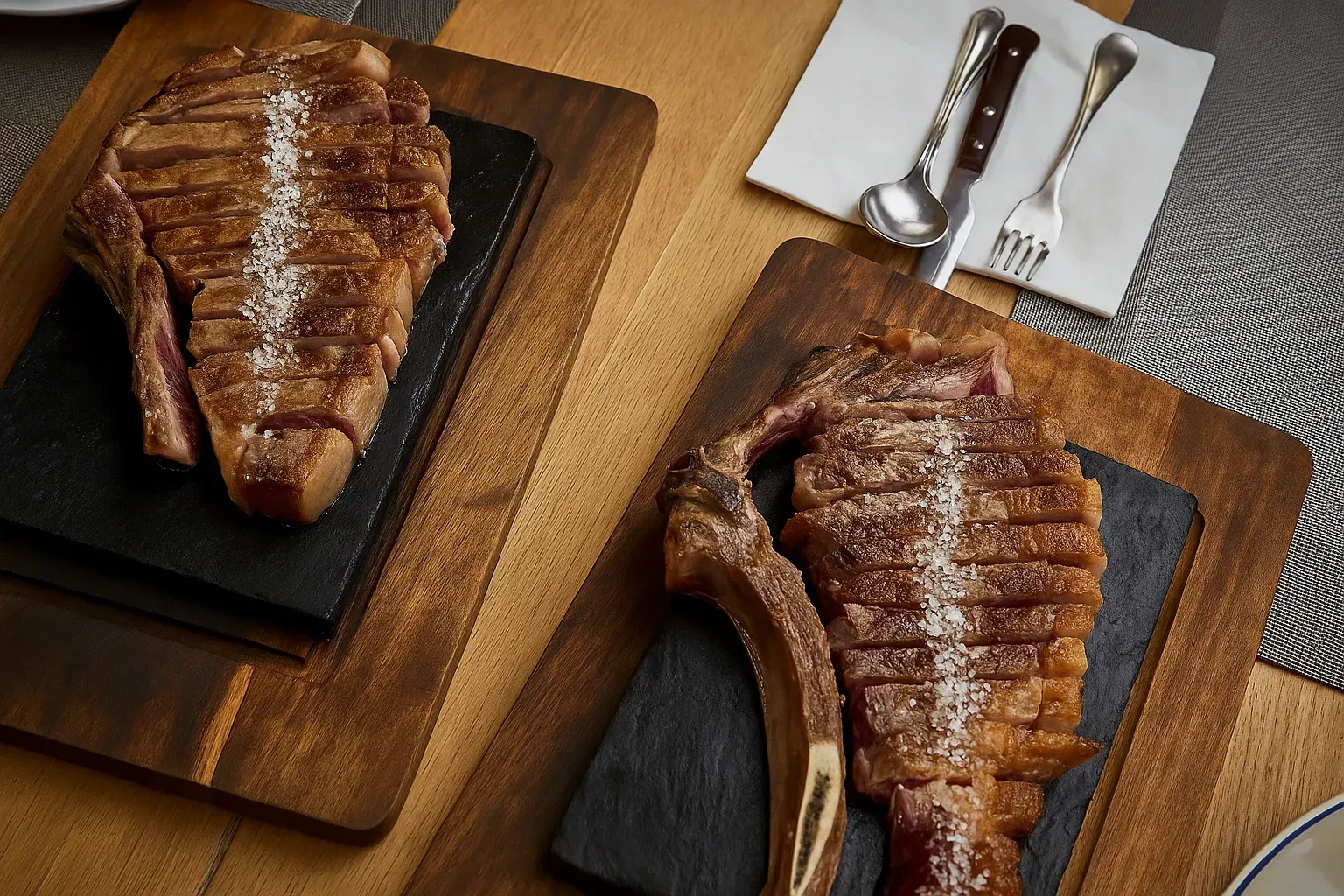 Dos filetes cortados sobre tablas de madera, cubiertos sobre una servilleta.