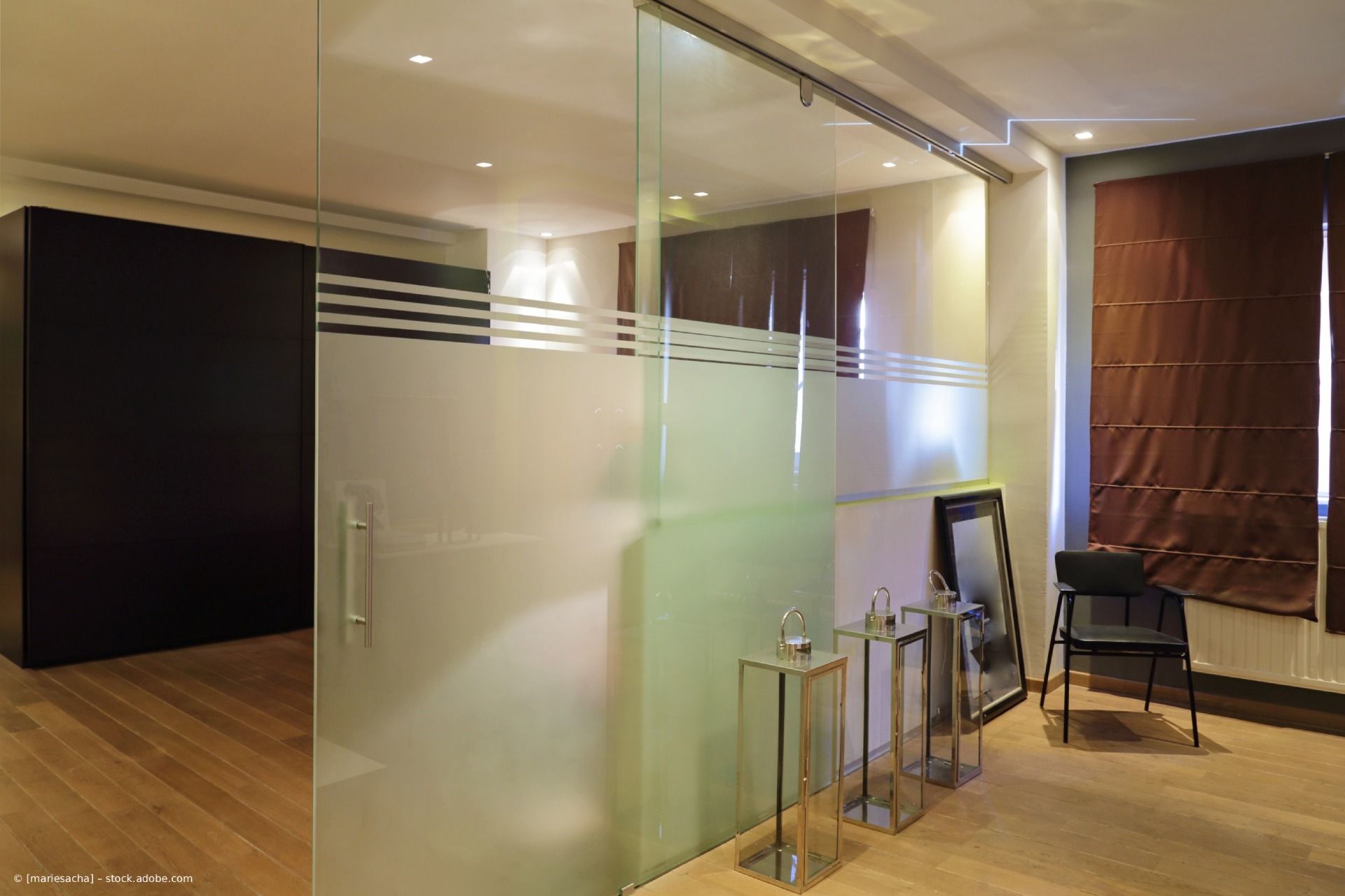 Moderne Bürolobby mit Milchglastrennwänden, Holzböden und Stühlen am Fenster