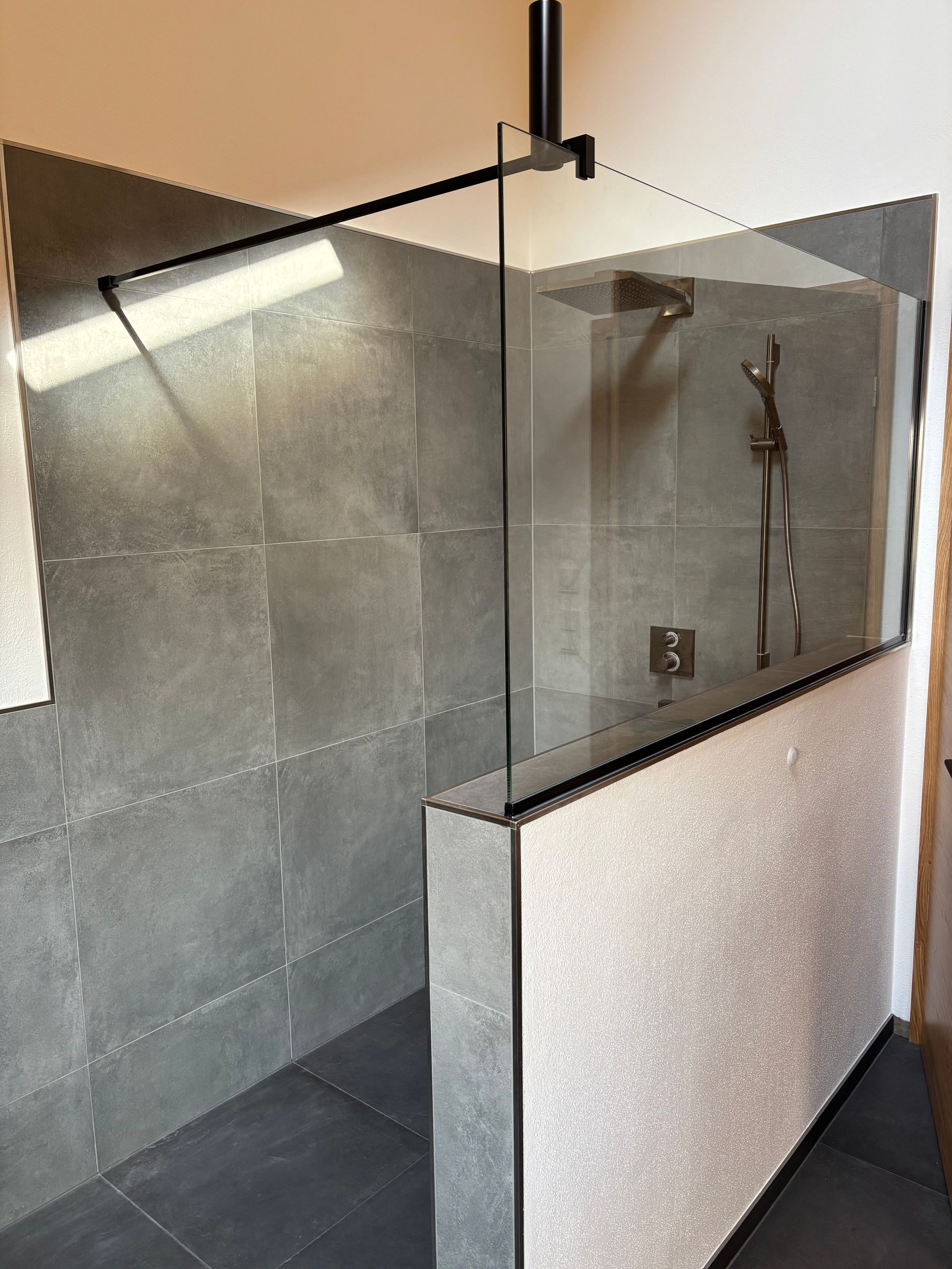 Modernes Badezimmer mit Glasdusche, grauem Waschtisch und holzvertäfelter Decke