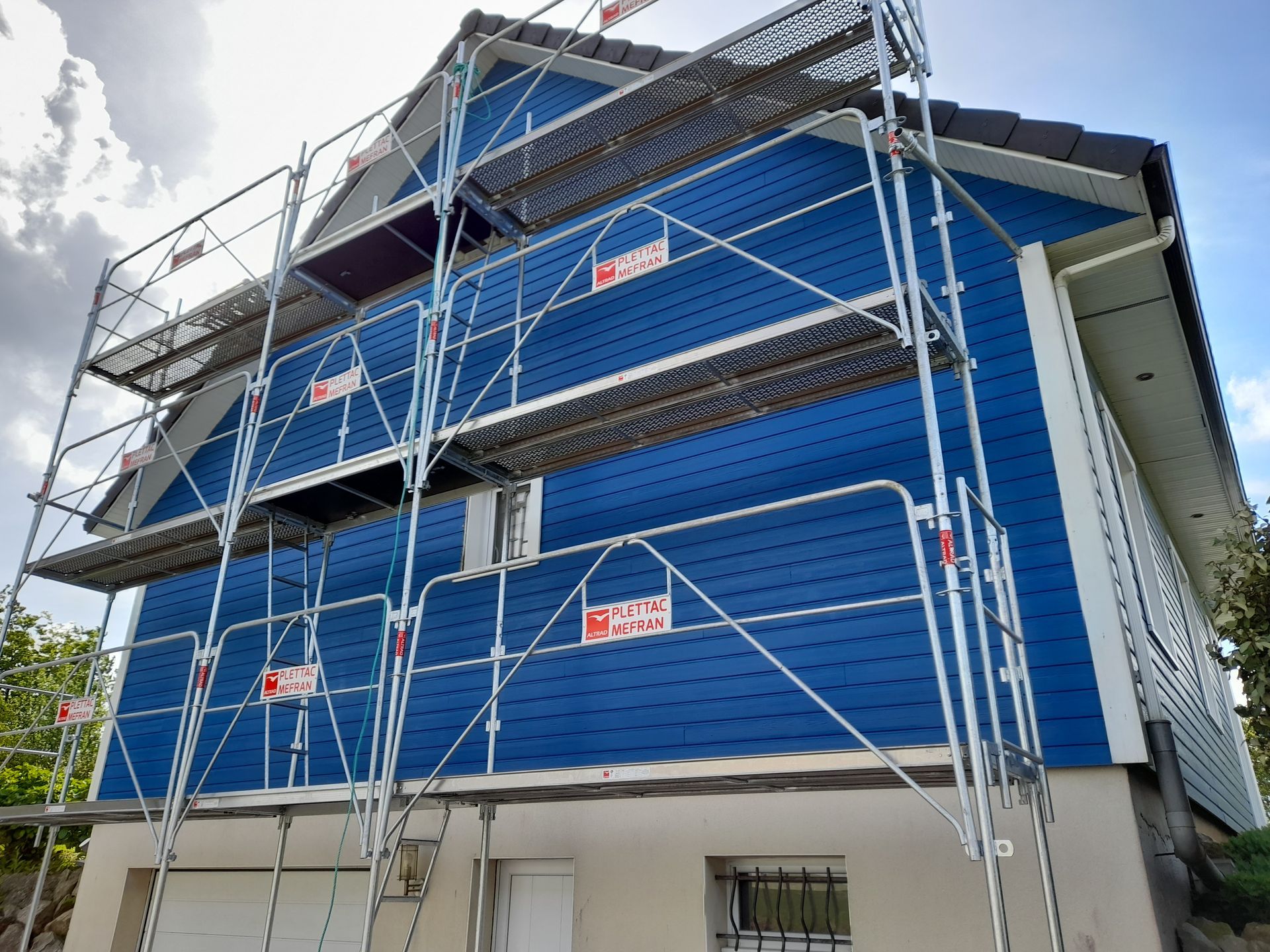 Échafaudage devant la façade d'une maison peinte en bleue