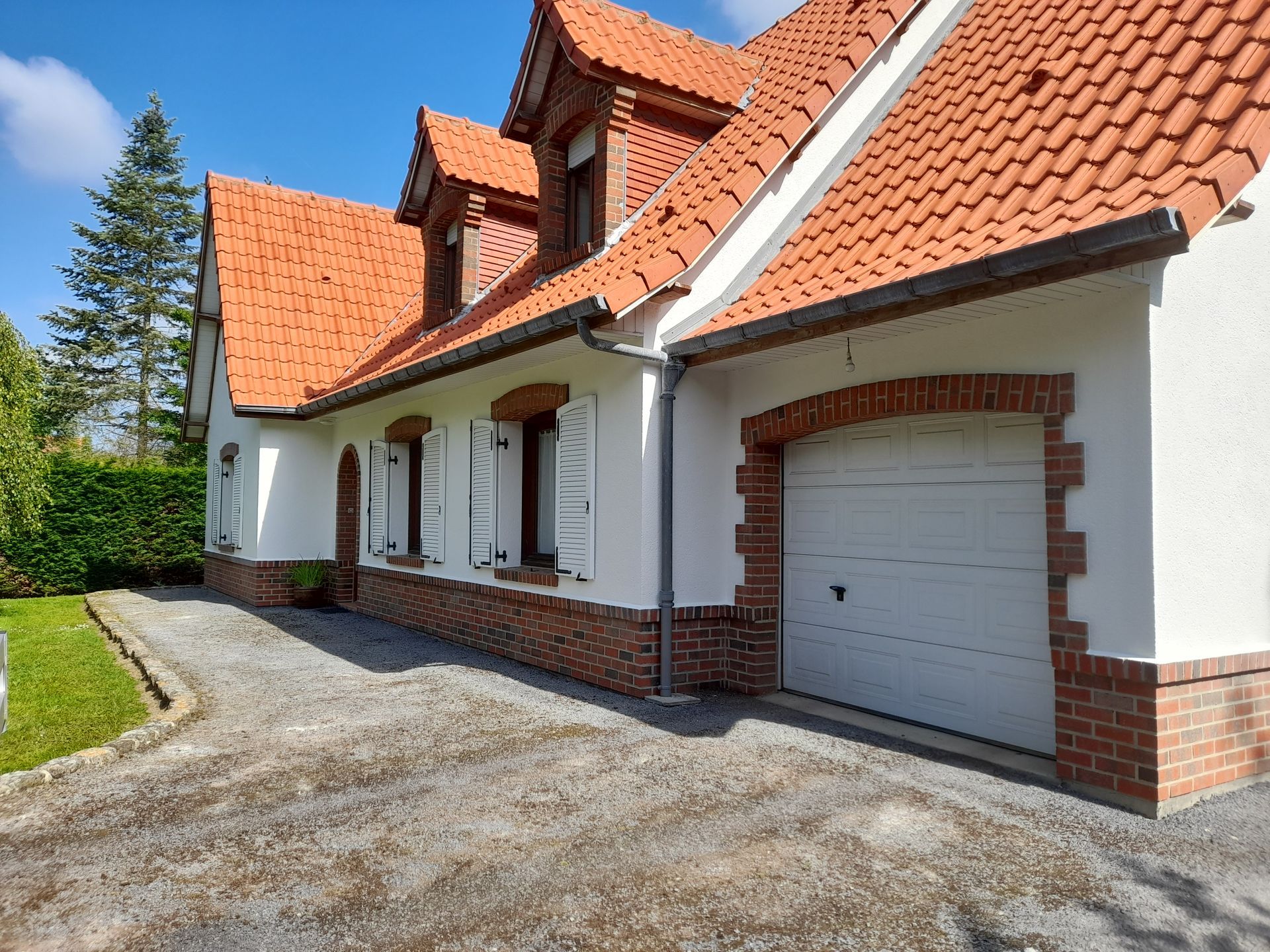 Vue sur le devant d'une maison avec toiture en tuiles