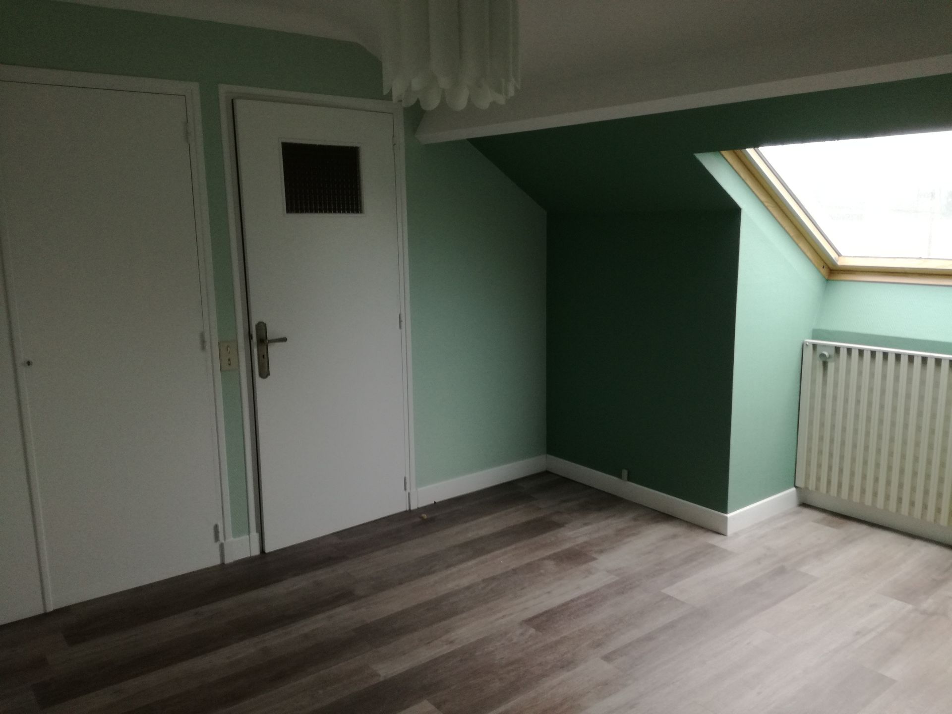 Intérieur d'une pièce mansardée peinte en vert