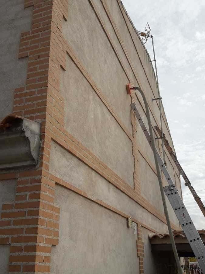 Una escalera está fijada al costado de un edificio.