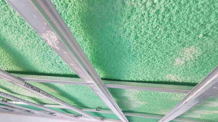 Un primer plano de un techo verde con estructura de metal.