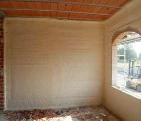 Una habitación con una pared de ladrillo y una ventana.