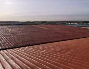 Un primer plano de un techo rojo con un paisaje al fondo.