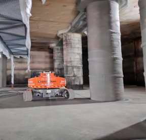 Un robot está sentado debajo de un puente en un edificio.