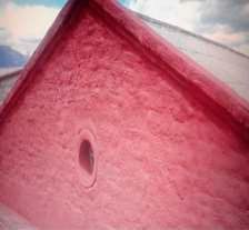 Un primer plano de una pared rosa con un agujero en ella.