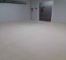 Una habitación con suelo blanco y una puerta.