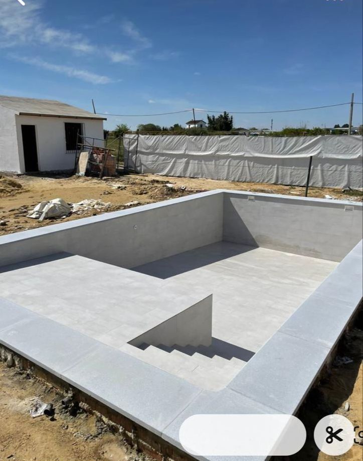 Se está construyendo una gran piscina en un campo de tierra.