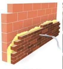 Una pared de ladrillos con espuma aplicada sobre ella.