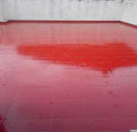 Un piso rojo con una pared blanca al fondo.