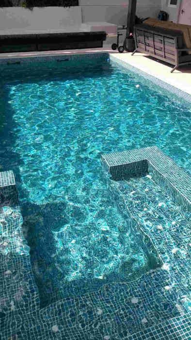 Una gran piscina llena de agua azul y escaleras que conducen a ella.