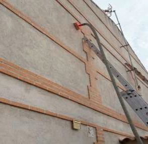 Una escalera está fijada al costado de un edificio.