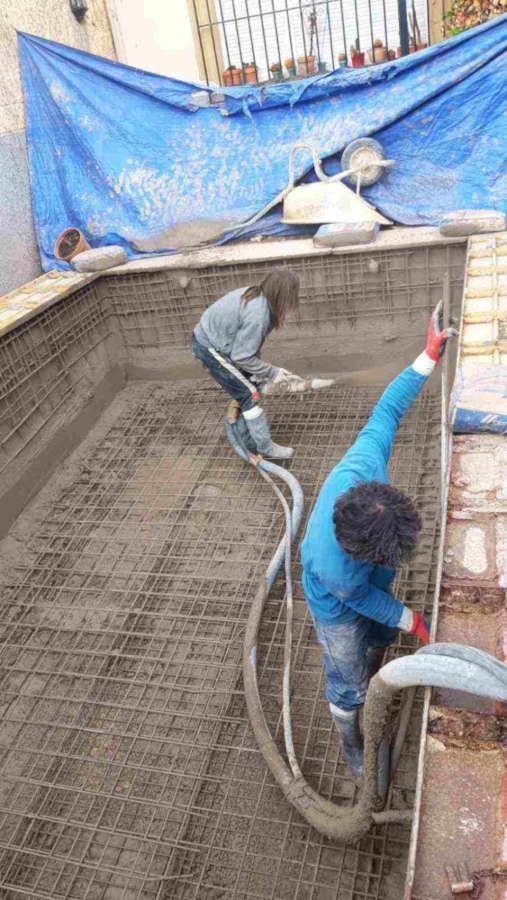 Una pareja está trabajando en una piscina.