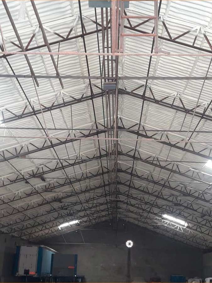 El interior de un gran edificio con techo de metal.