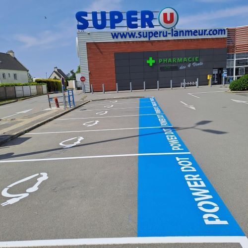Marquage au sol en bleu et blanc pour indiquer en parking extérieur les places pour voitures électriques